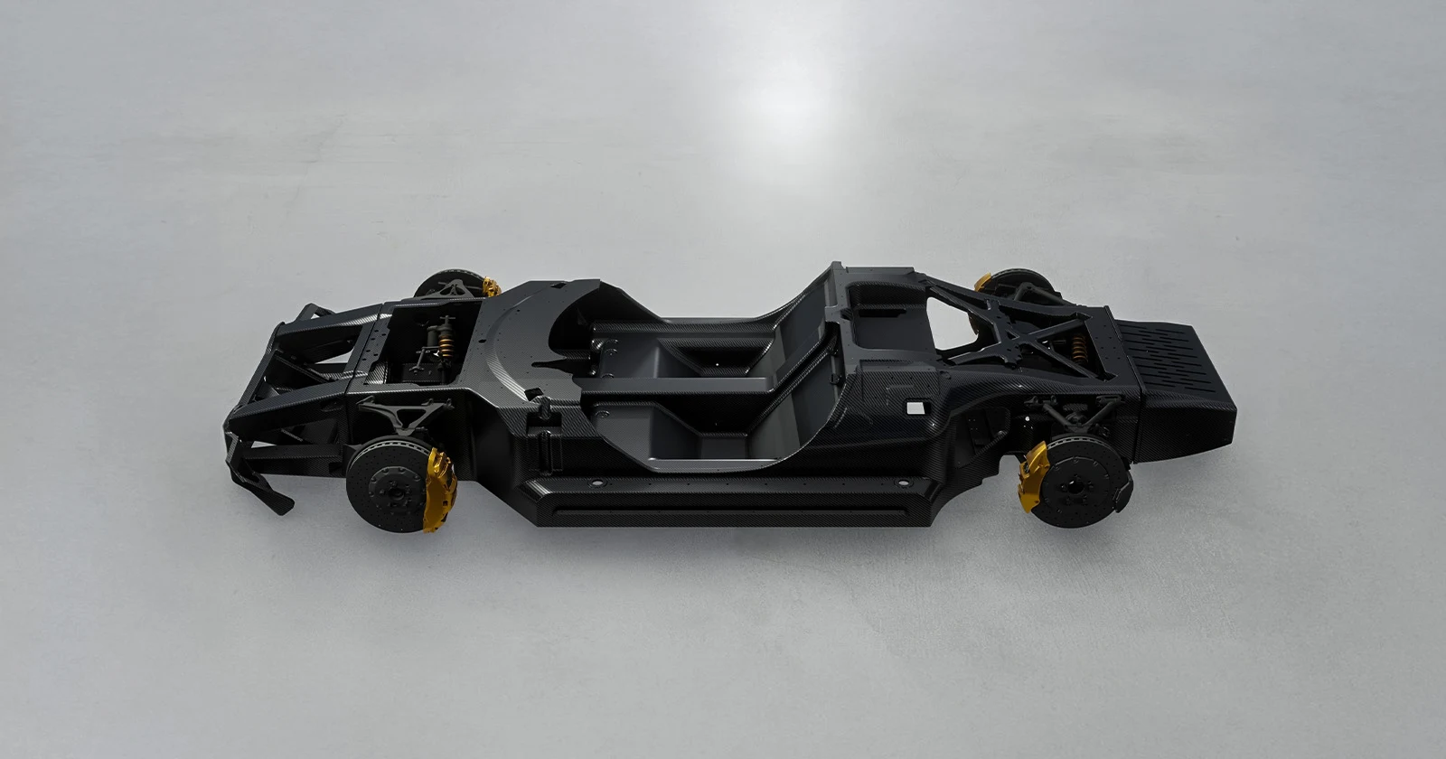 Black monocoque chassis of a sports car on light grey background